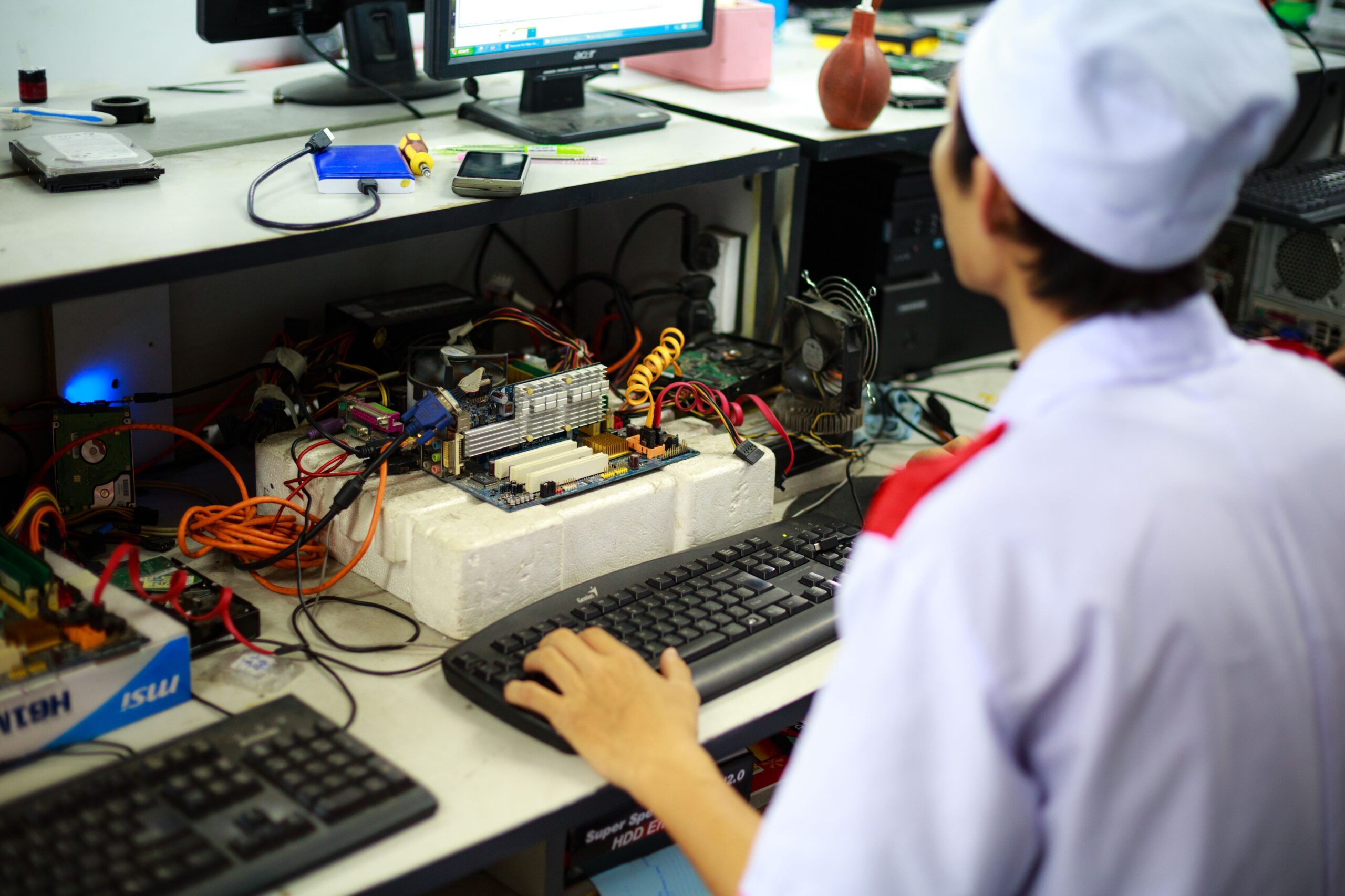 Técnico especializado realizando una auditoría de hardware en una placa base de ordenador.