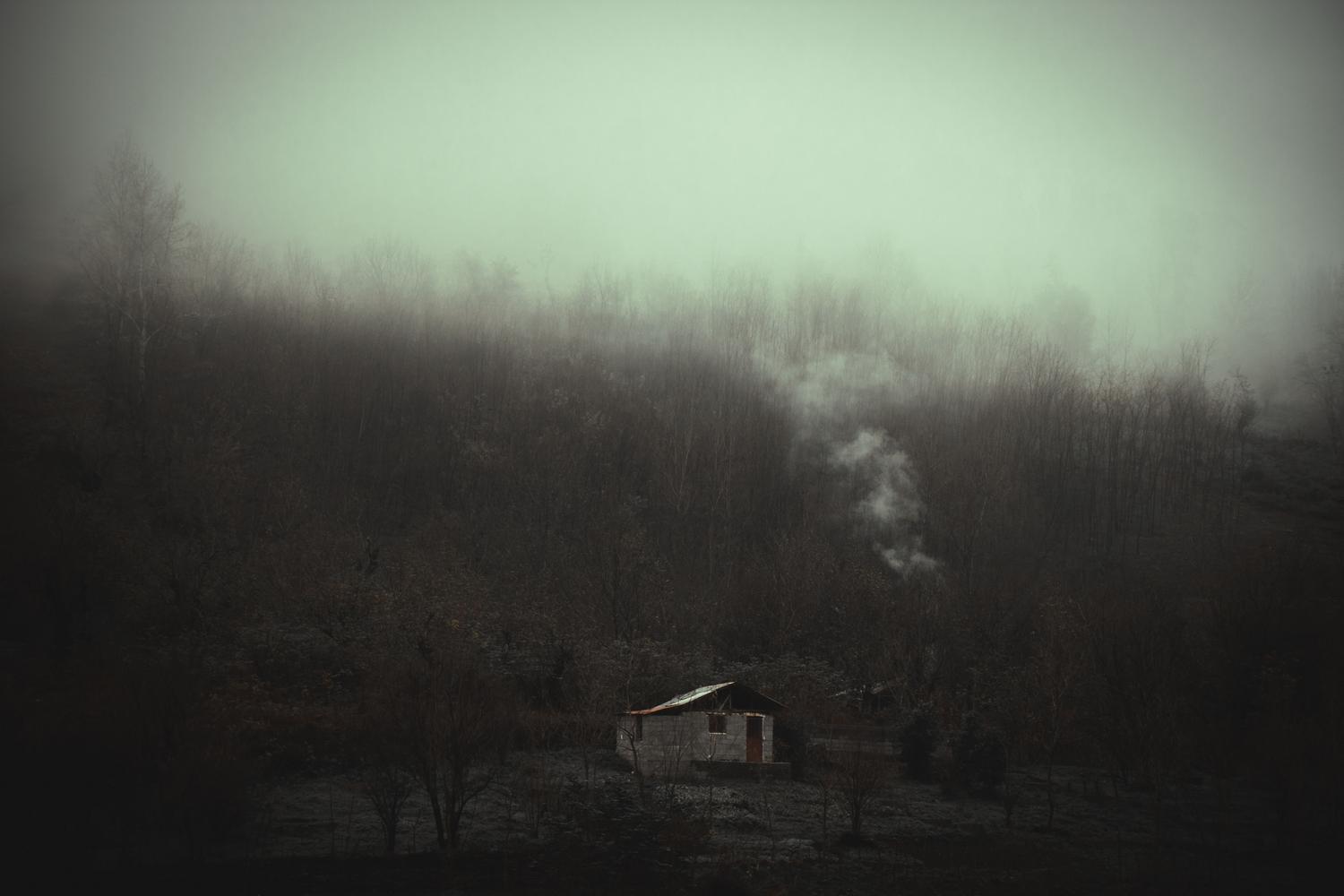 Cabaña solitaria en un bosque brumoso, representando los misterios y puntos de interés ocultos en el mapa
