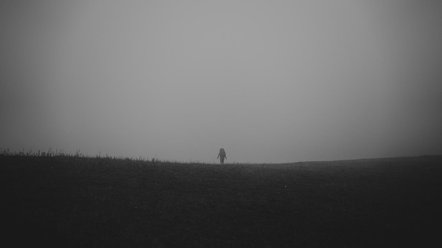 Silueta de un personaje en un campo brumoso y desolado, simbolizando la soledad y el desafío del protagonista Rémi