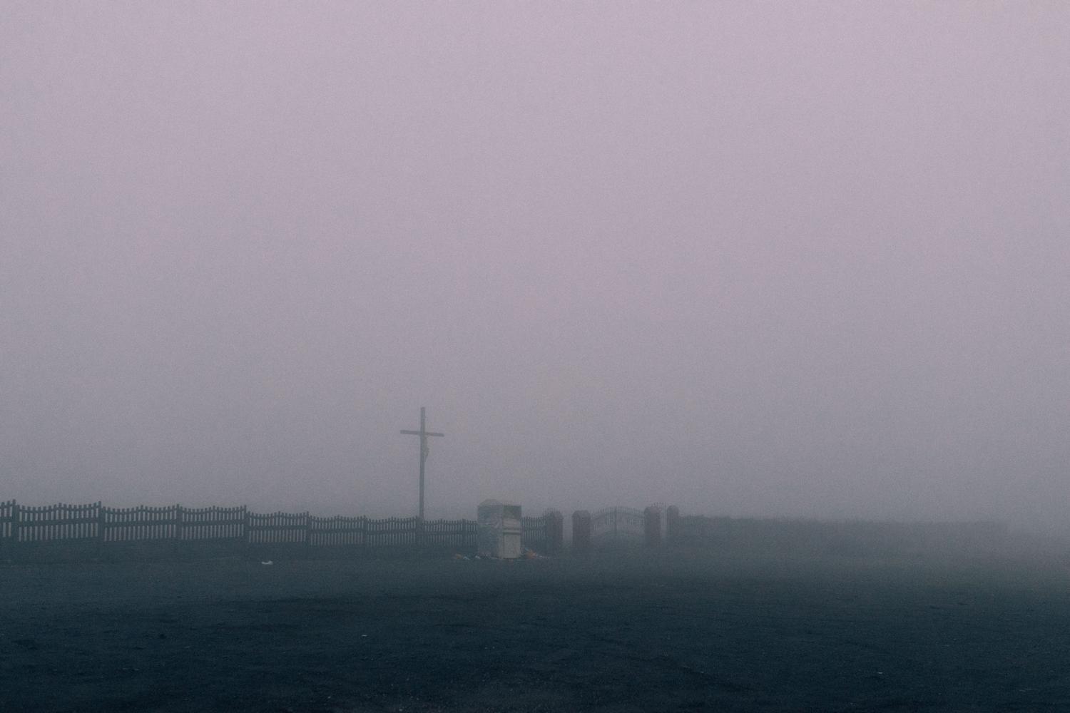 Cementerio envuelto en niebla, ilustrando el componente de horror folclórico y misterio del juego