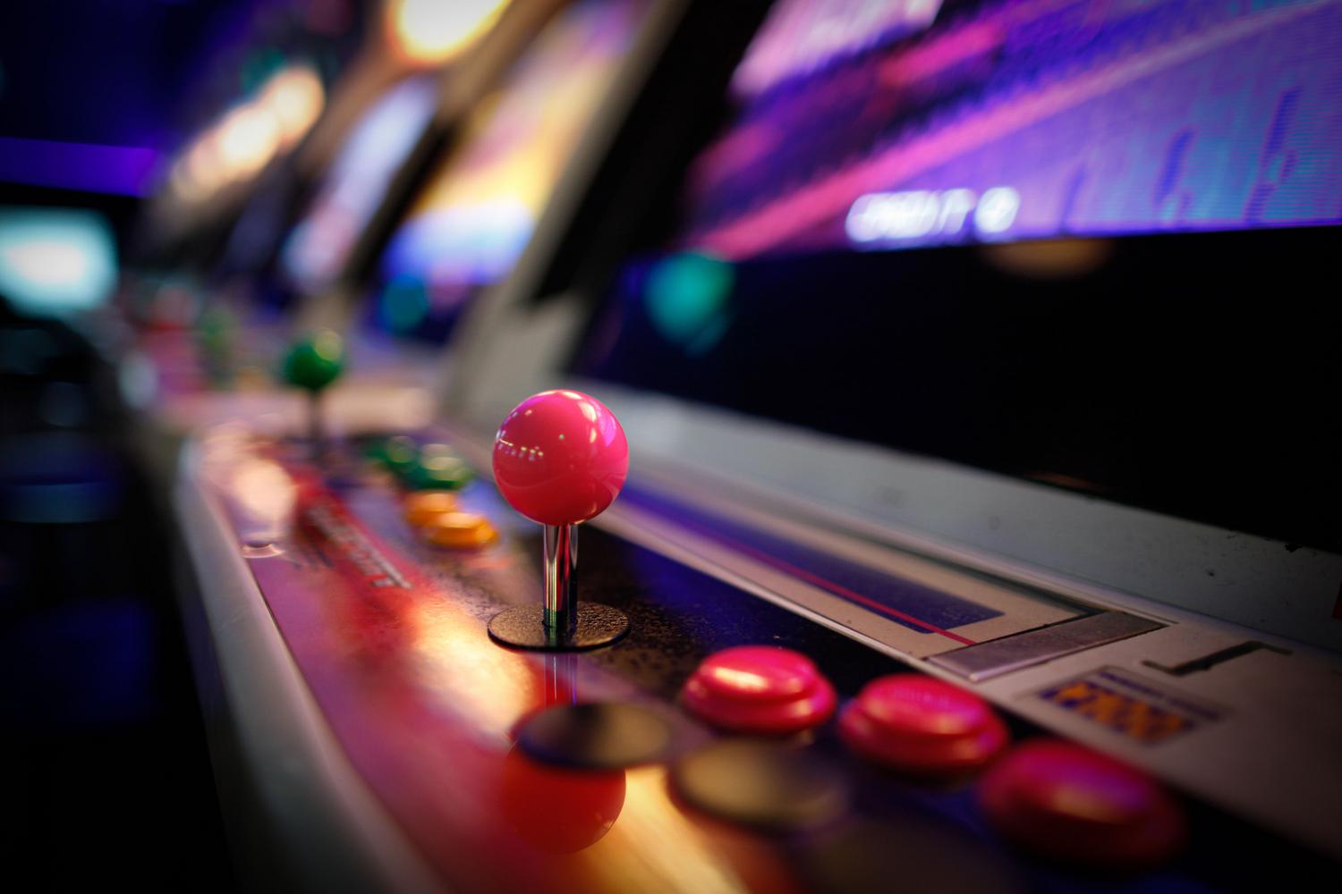 Detalle de un joystick de máquina arcade vintage con luces de neón, evocando los inicios de Donkey Kong en los salones recreativos de 1981.