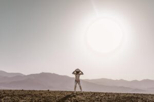 Astronauta solitario en un paisaje desértico y alienígena, representando la atmósfera de aislamiento y vulnerabilidad de la saga Metroid.