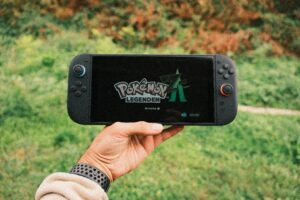 Persona sosteniendo una consola portátil con un juego de Pokémon en pantalla, ideal para introducir la guía de juego.