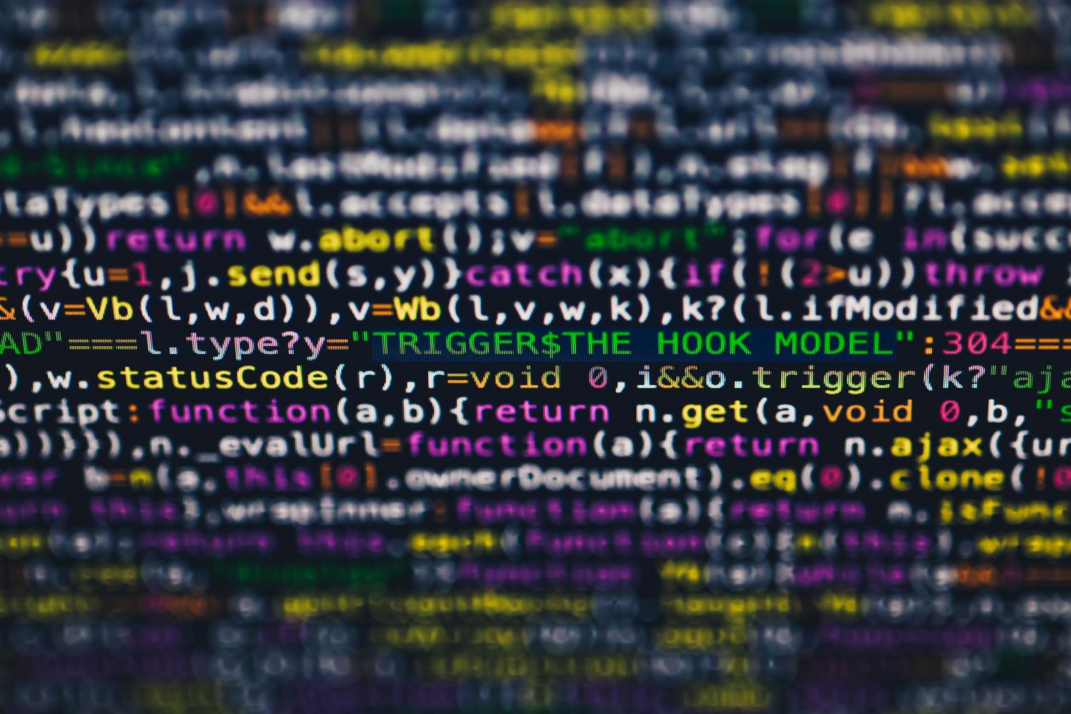 Imagen macro de código de programación en una pantalla con colores vibrantes, simbolizando la complejidad del desarrollo de software.