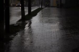 Una calle urbana desolada y sombría al anochecer, reflejando la atmósfera opresiva de Raccoon City.