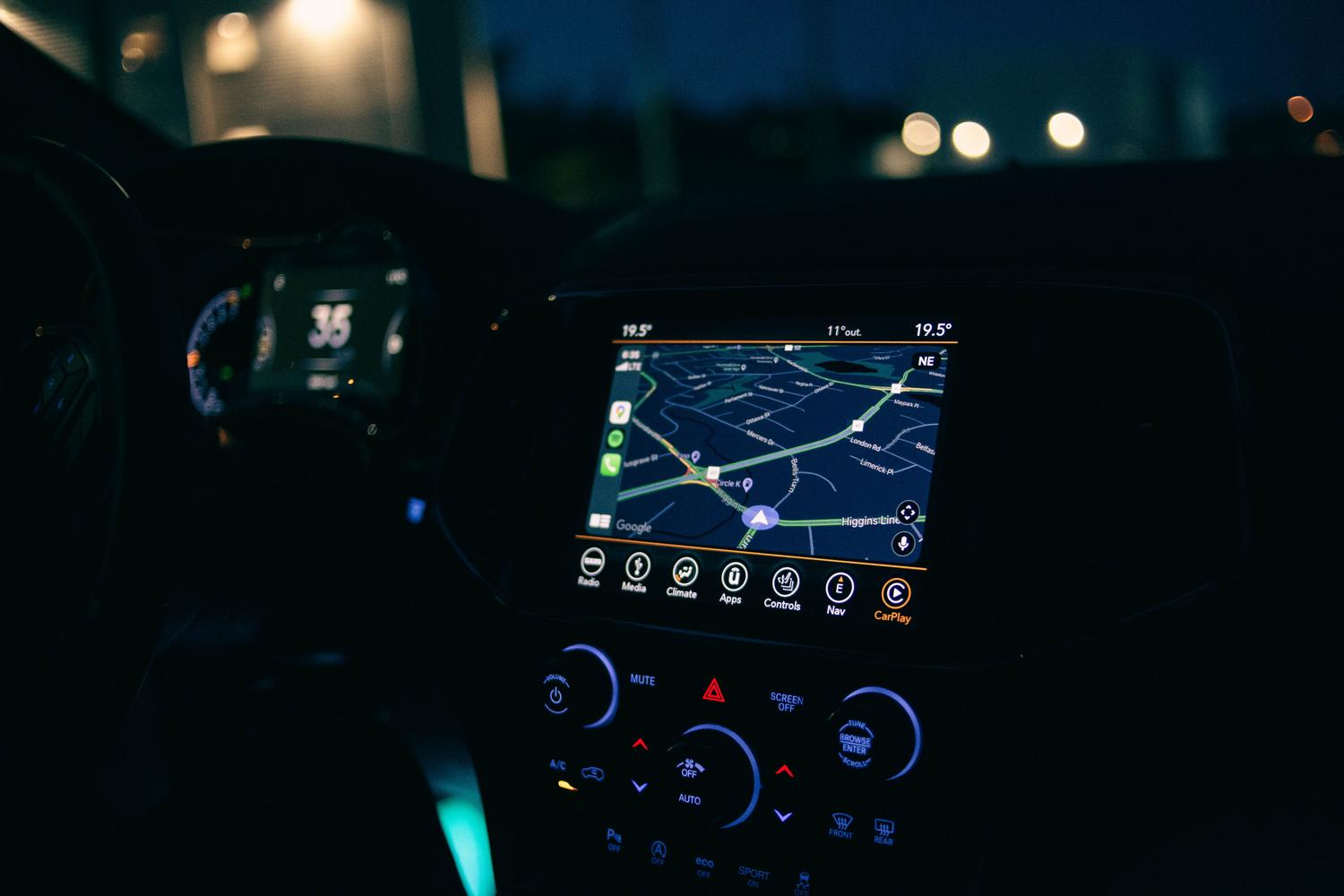 Primer plano de un sistema de navegación GPS iluminado en el interior de un coche, representando la exploración del mapa de Leonida.