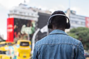 Persona con auriculares explorando una ciudad bulliciosa, ideal para ilustrar viajes y turismo con traducción por IA