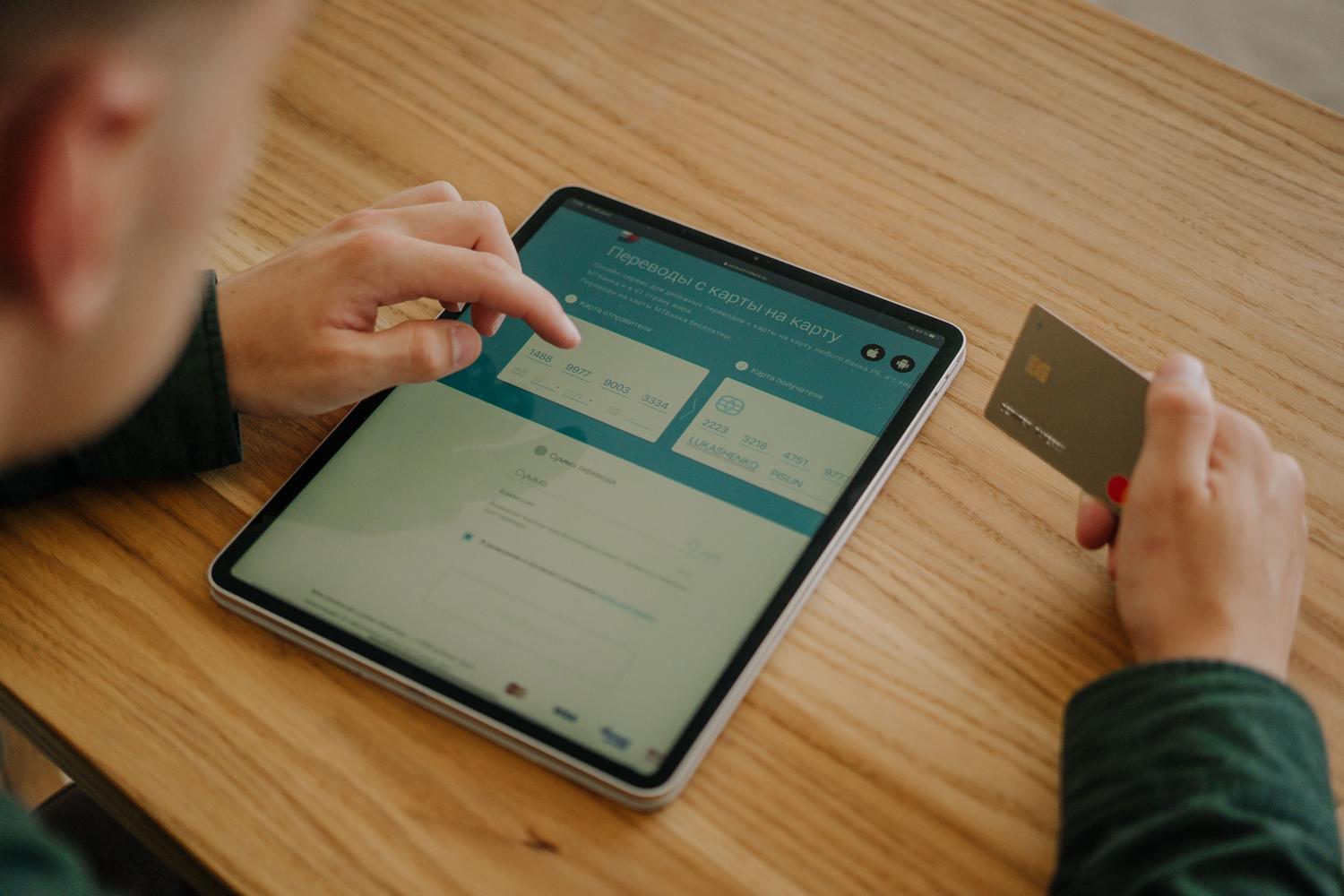 Persona introduciendo datos de una tarjeta de crédito en una tablet.