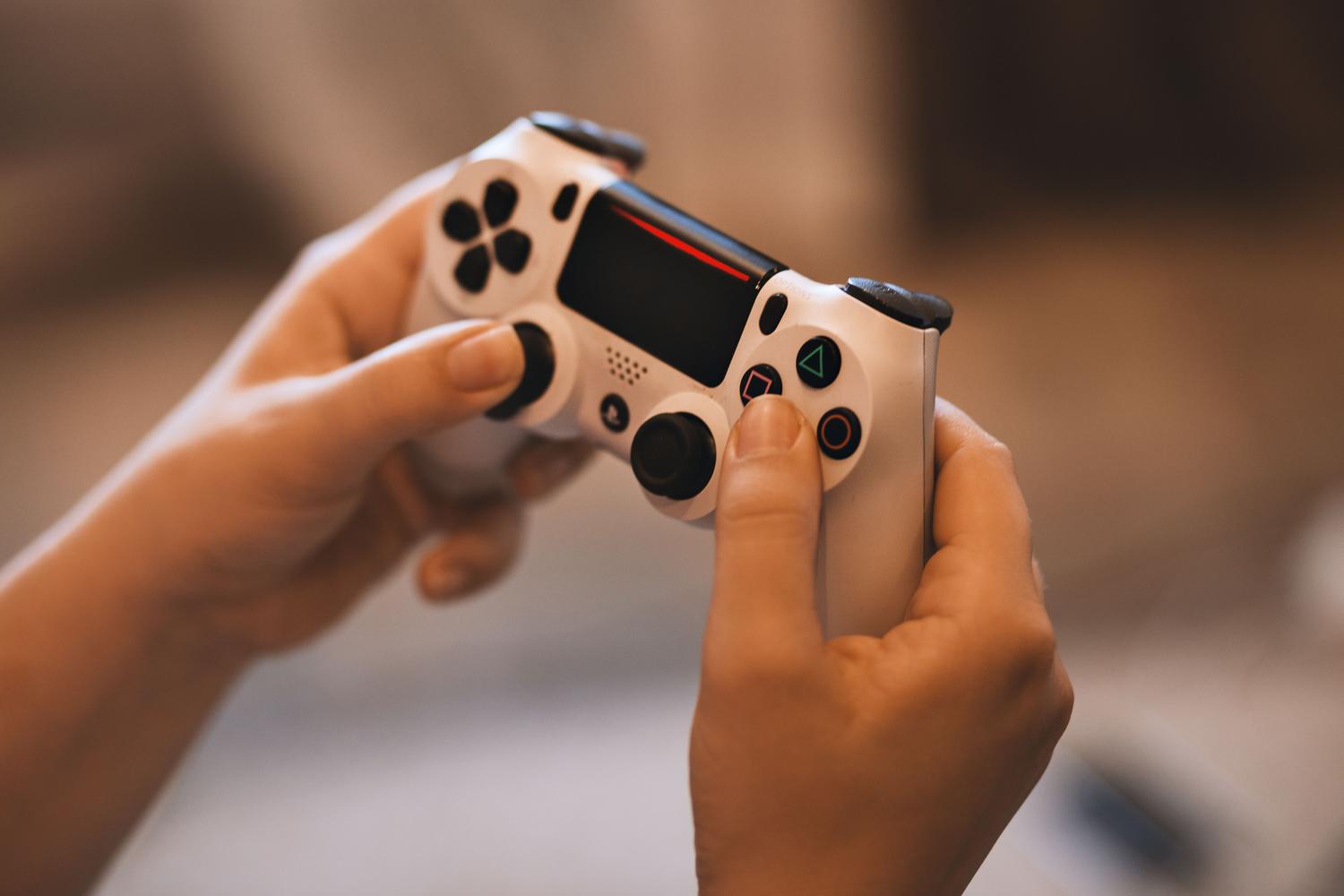 Manos de un jugador sosteniendo un mando de PlayStation 4 listo para jugar.