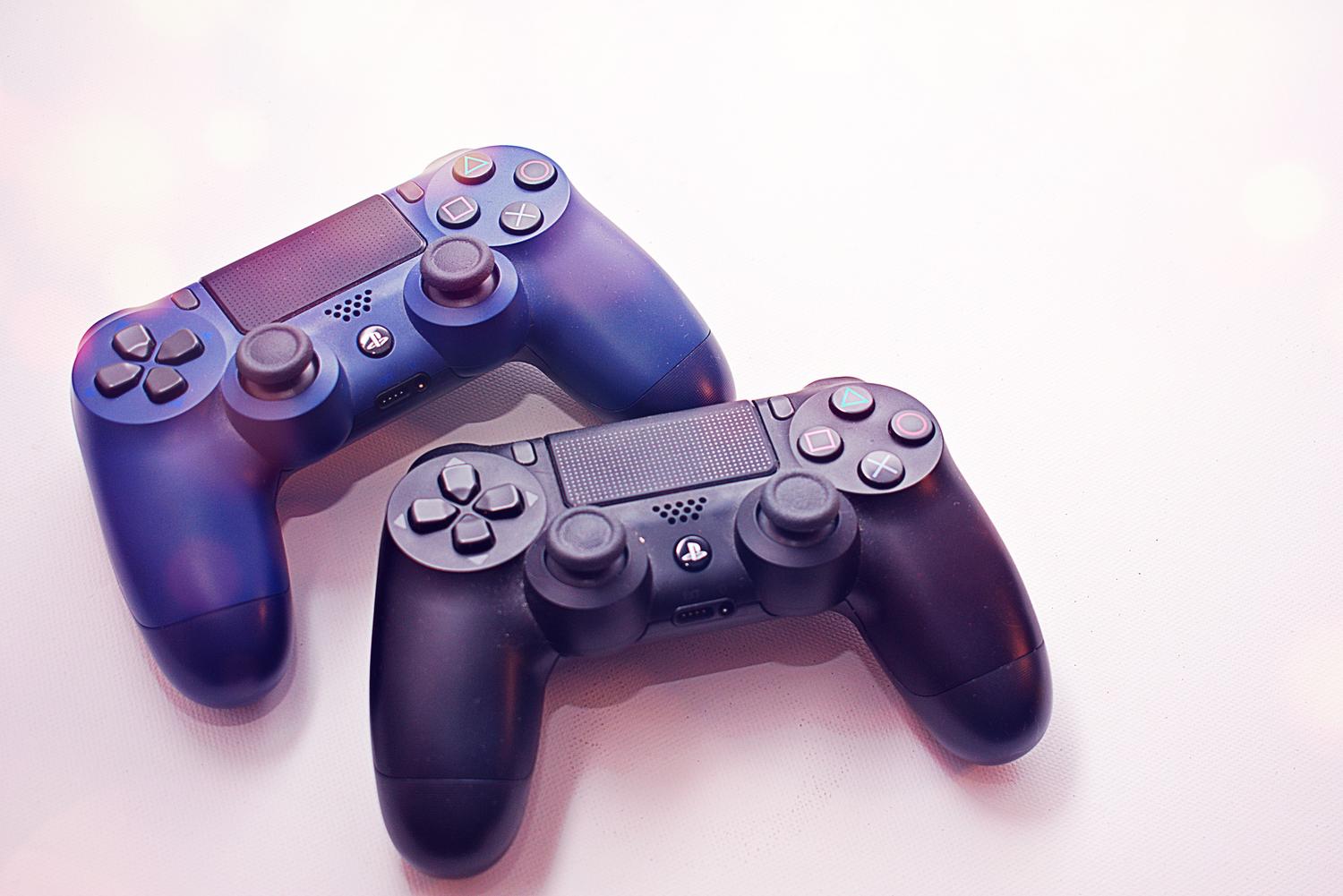 Dos mandos DualShock 4 de PlayStation 4 sobre un fondo blanco limpio.