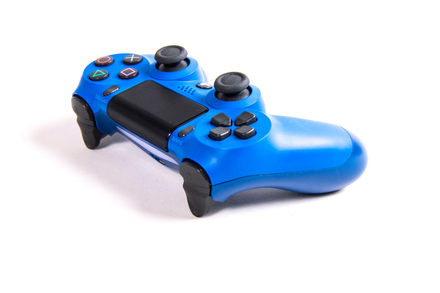 Detalle de un mando inalámbrico de PS4 en color azul sobre fondo blanco.