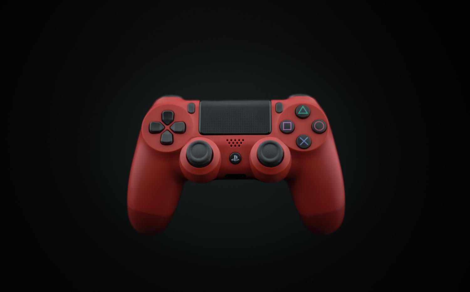 Primer plano de un mando de PS4 en color rojo sobre un fondo oscuro.