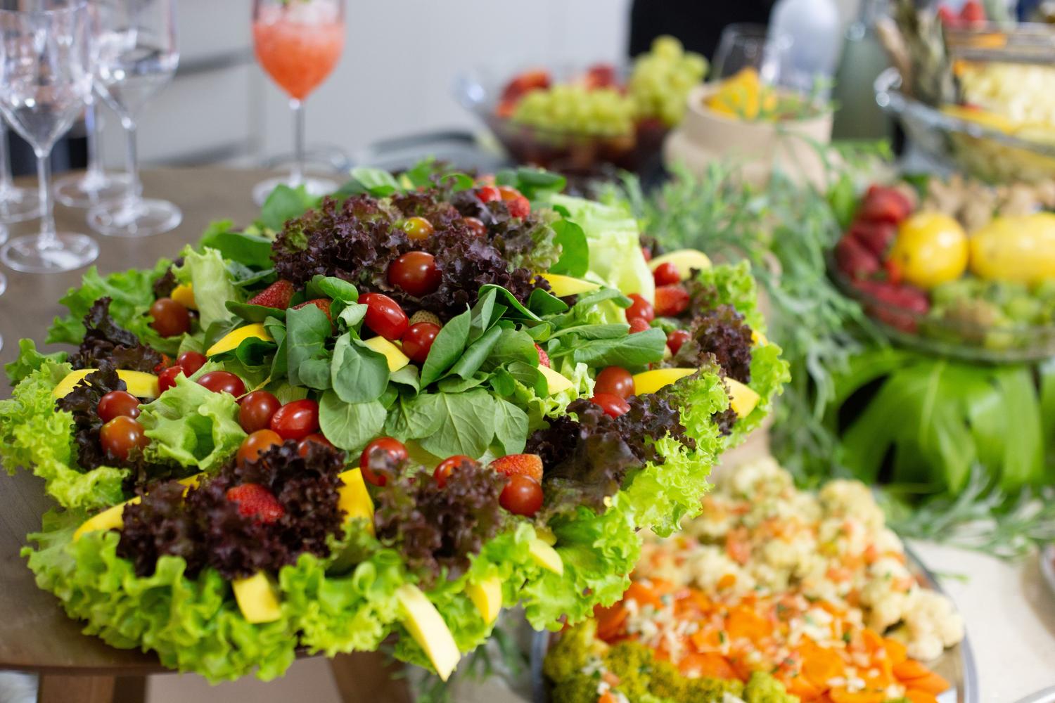 Ensalada mixta con hojas verdes, tomates cherry y mango, destacando el consumo de verduras de hoja verde.