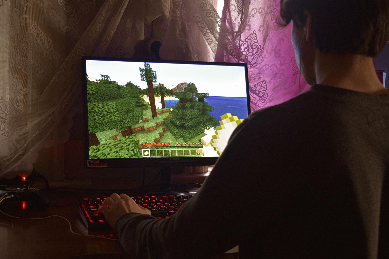 Hombre concentrado jugando en su ordenador, representando al usuario que busca optimizar sus gastos en juegos.