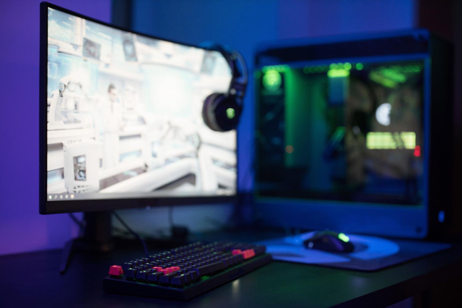 Setup de gaming moderno con monitor curvo y teclado RGB, representando el entorno típico del jugador.