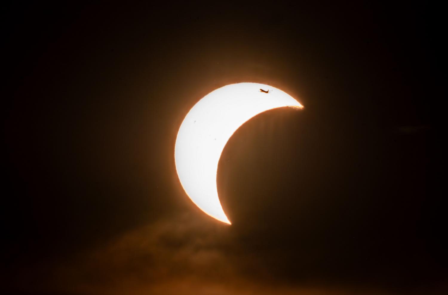 Vista dramática de un eclipse solar parcial mostrando la forma de creciente, fase en la que es imprescindible usar protección ocular.