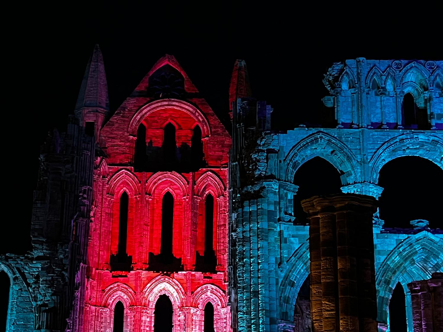 Ruinas góticas iluminadas bajo un cielo nocturno, evocando la atmósfera asfixiante de Castlevania Ruinas góticas iluminadas bajo un cielo nocturno, evocando la atmósfera asfixiante de Castlevania