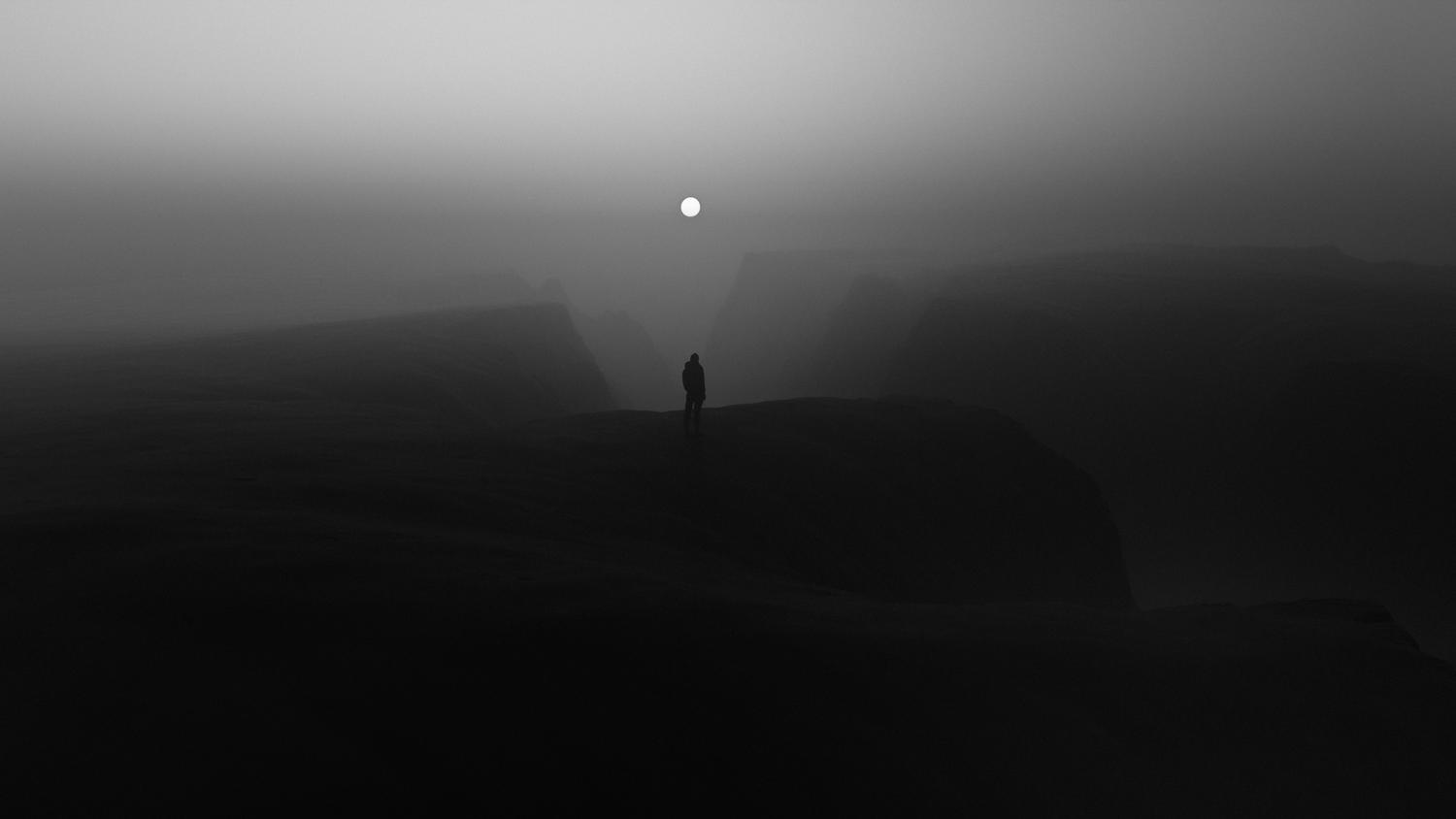 Figura solitaria en un paisaje brumoso y oscuro, representando el viaje del héroe elegido en un RPG