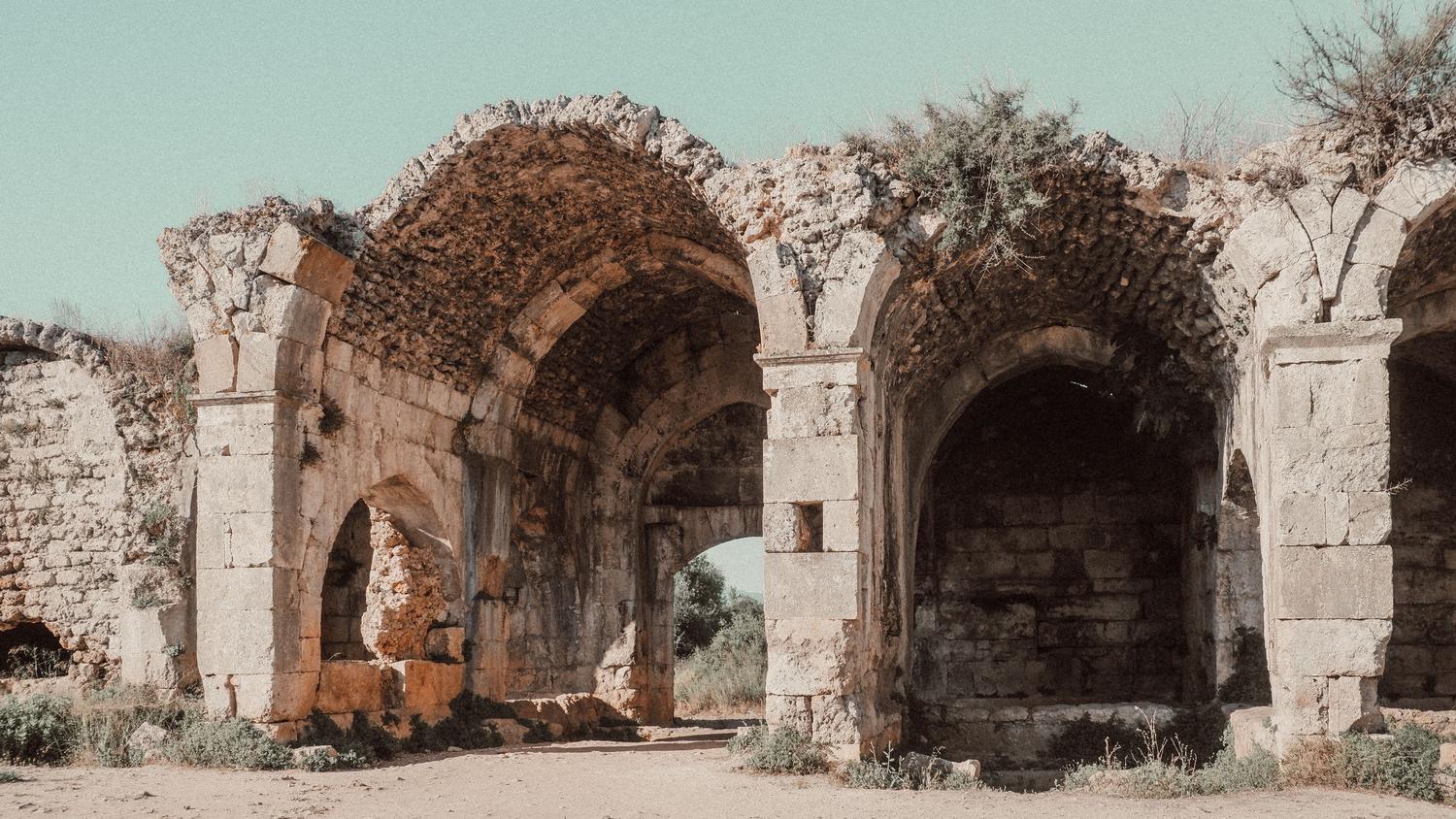 Ruinas antiguas de arcos de piedra, evocando la decadencia y civilizaciones caídas de juegos como Dark Souls