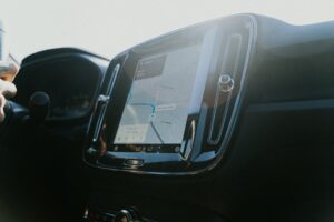 Pantalla táctil de navegación en el interior de un coche moderno mostrando Google Maps con ruta de navegación activa, ilustrando la integración de servicios Google en vehículos
