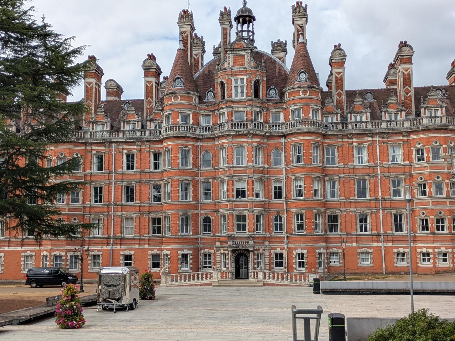 Arquitectura gótica victoriana del Royal Holloway College, ejemplificando el prestigio académico de las instituciones europeas mencionadas en el texto.