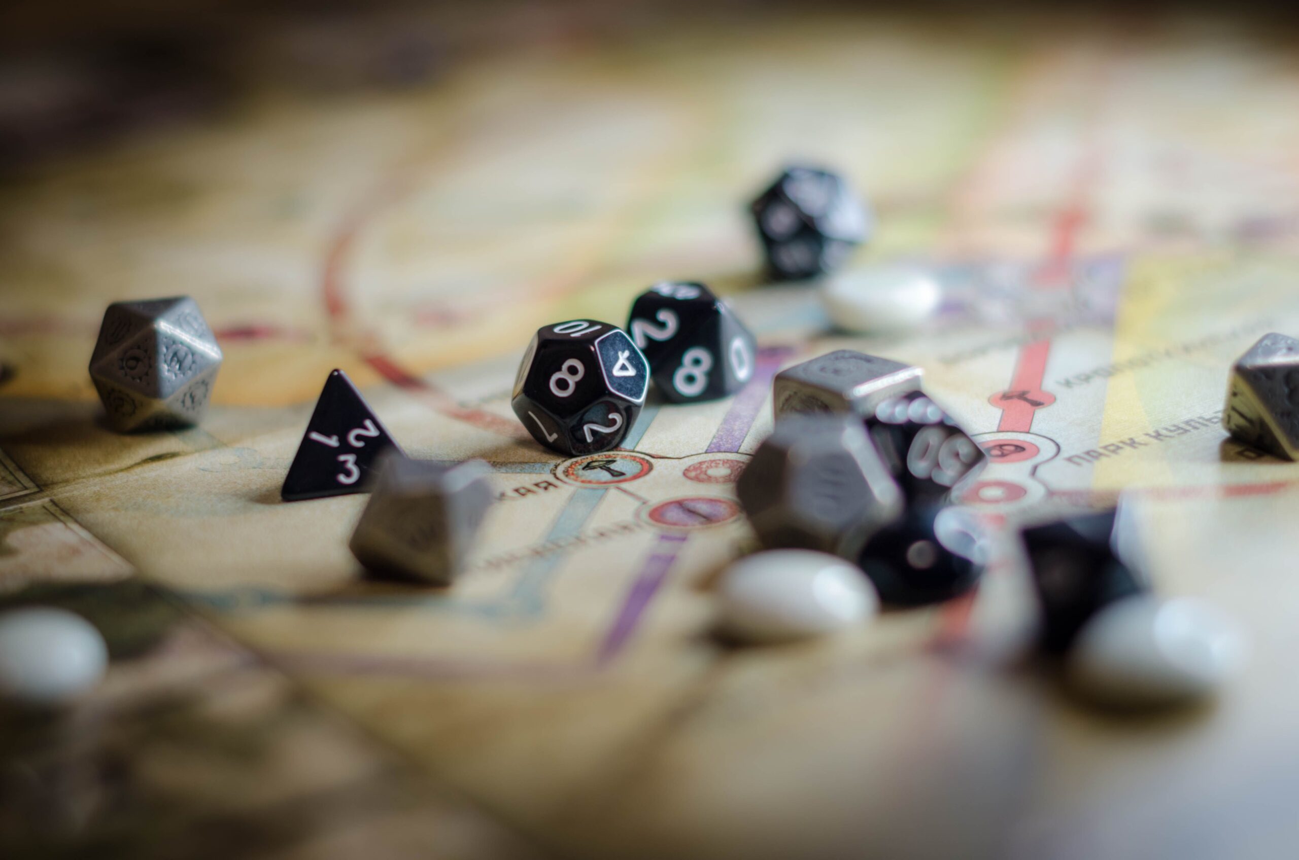 Dados poliedros de rol sobre un mapa, ilustrando la esencia de las misiones y la toma de decisiones en los videojuegos de aventura.