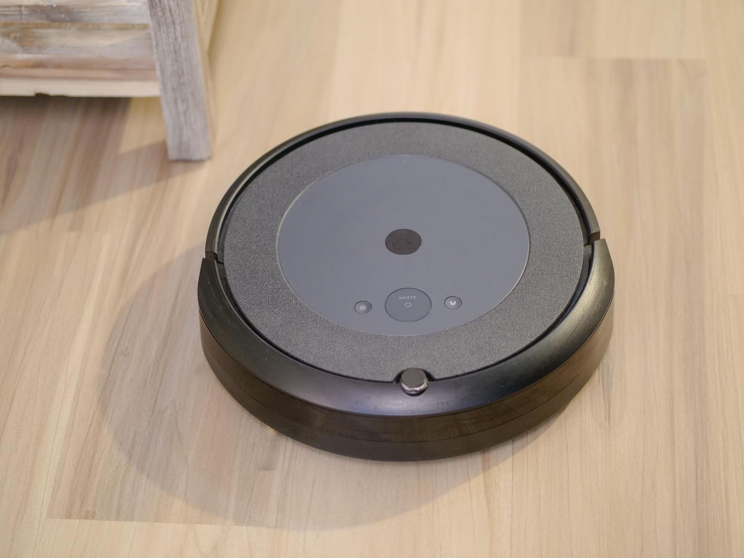 Primer plano de un robot aspirador moderno destacando sus sensores de navegación inteligente y tecnología de succión.