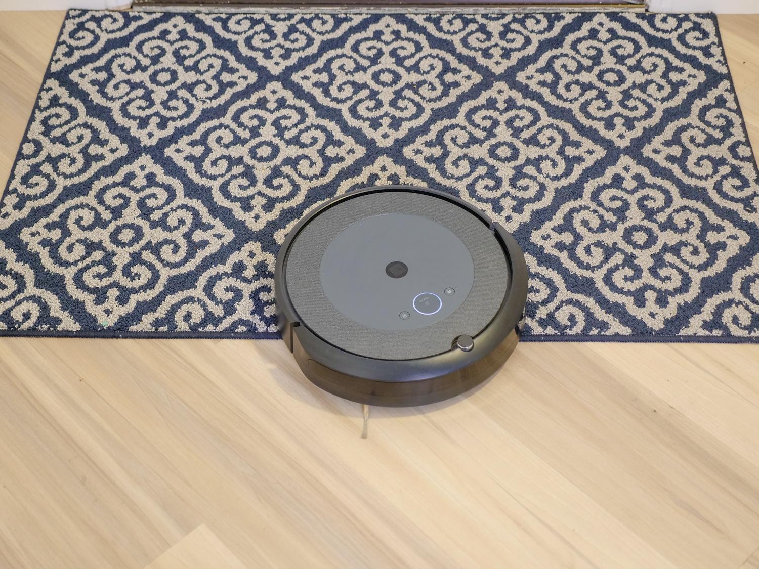 Robot aspirador limpiando una alfombra, ilustrando cómo el Smart Plan ajusta la potencia de succión según la superficie.