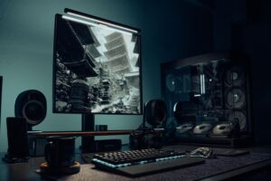Setup de PC gaming moderno con monitor y componentes iluminados, ideal para juegos exigentes como Nodus Fall.