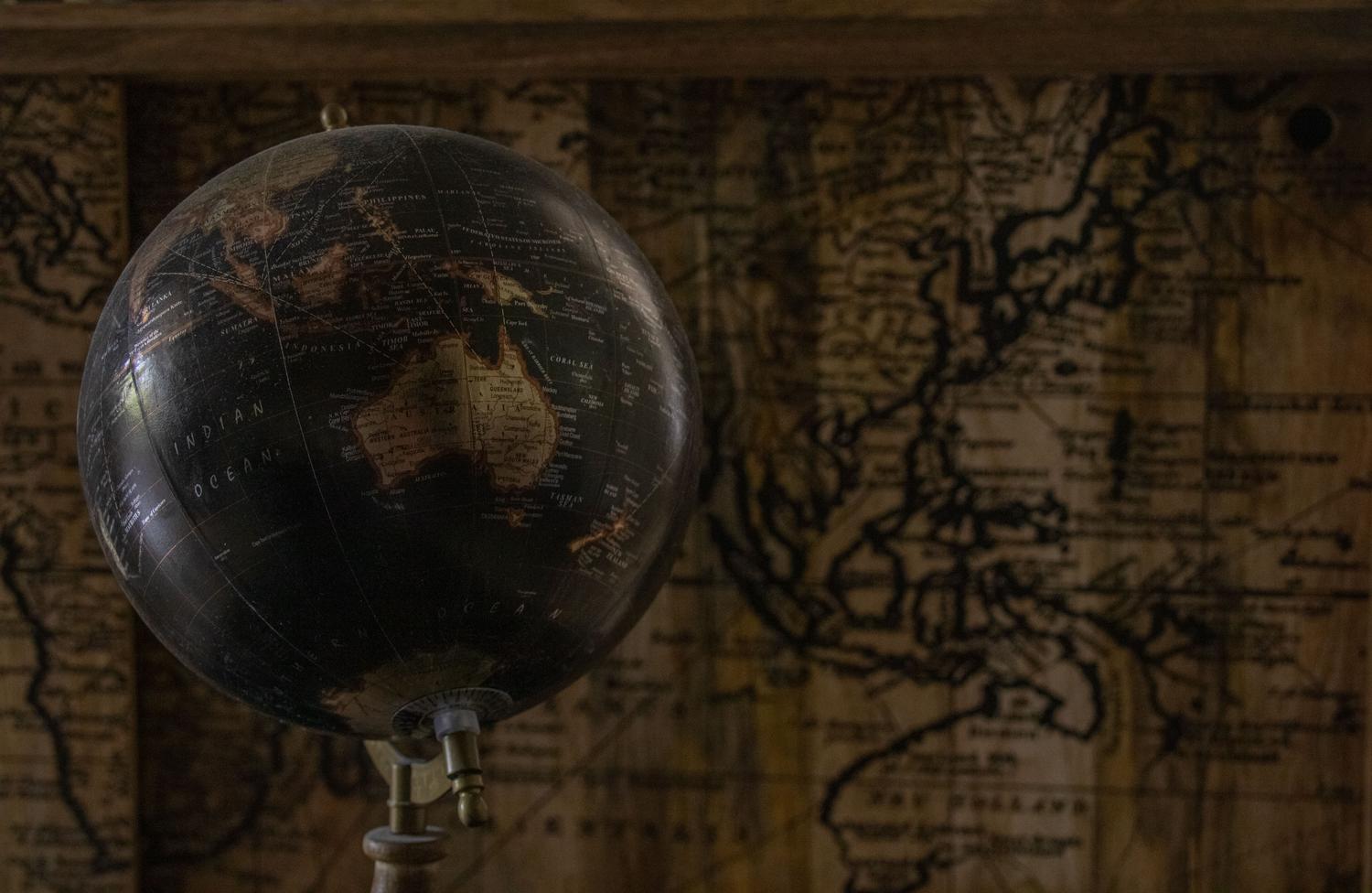 Globo terráqueo antiguo y mapa vintage que representan la expansión de civilizaciones en HUMANKIND 2.