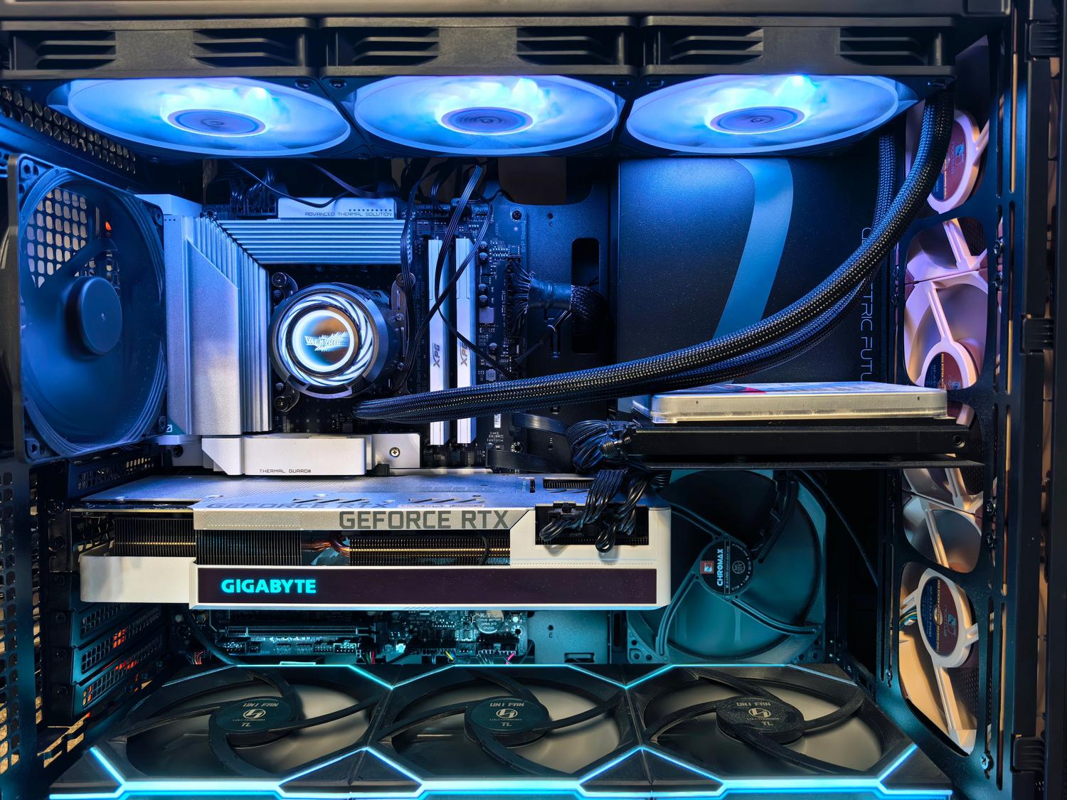 Primer plano del interior de un PC gaming con tarjeta gráfica NVIDIA GeForce RTX y sistema de refrigeración líquida.