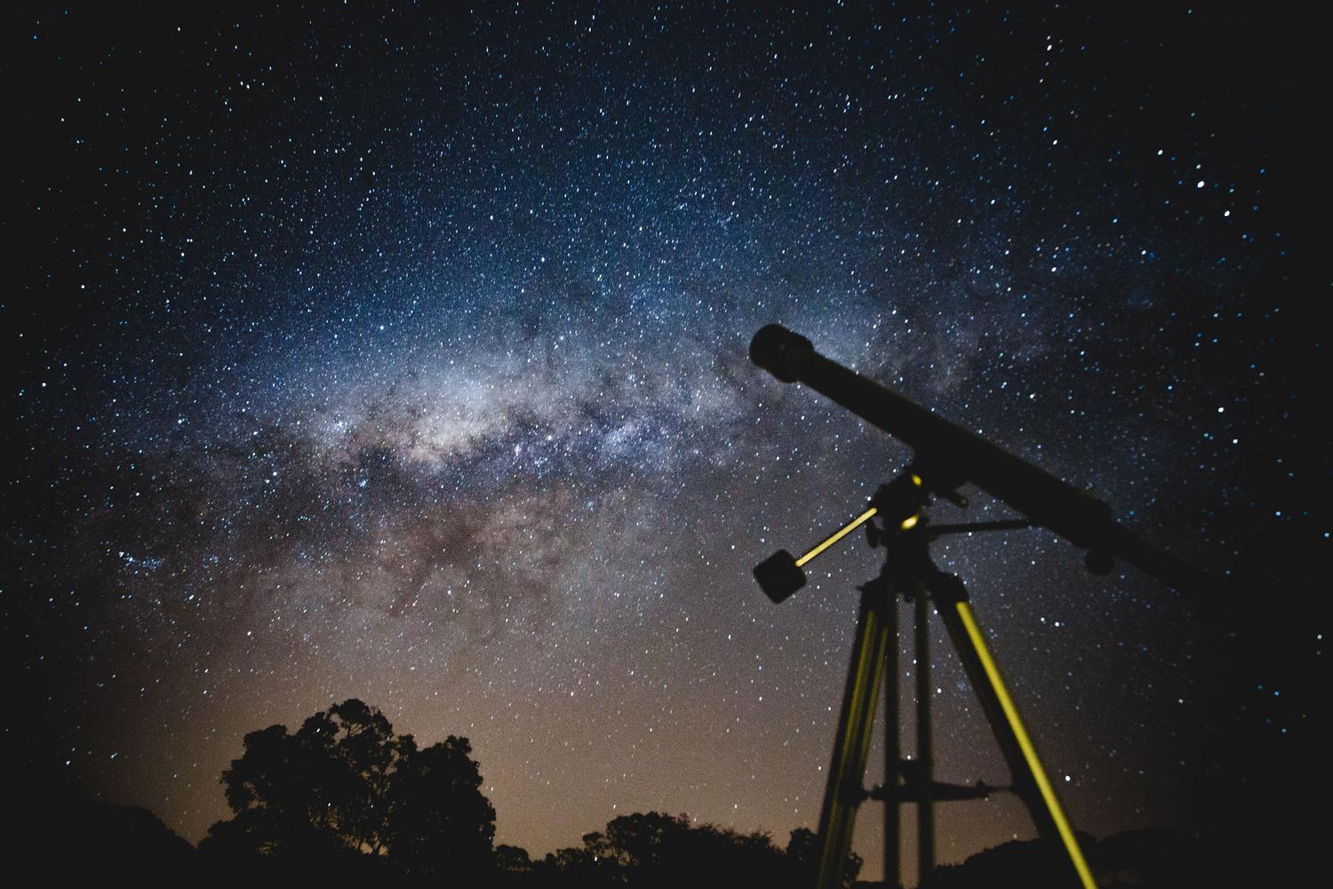 Telescopio profesional apuntando hacia un cielo nocturno estrellado, ideal para la observación de asteroides.