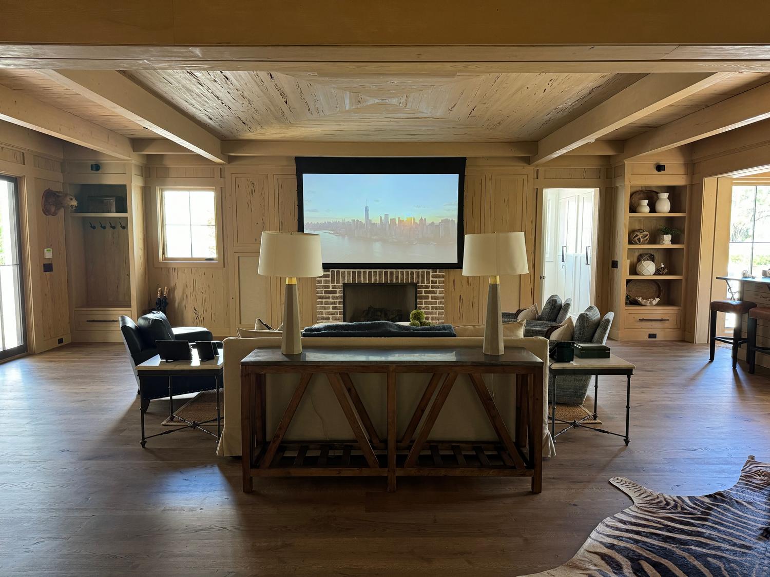 Configuración de home theater en un salón acogedor con pantalla de proyección y sistema de audio envolvente.