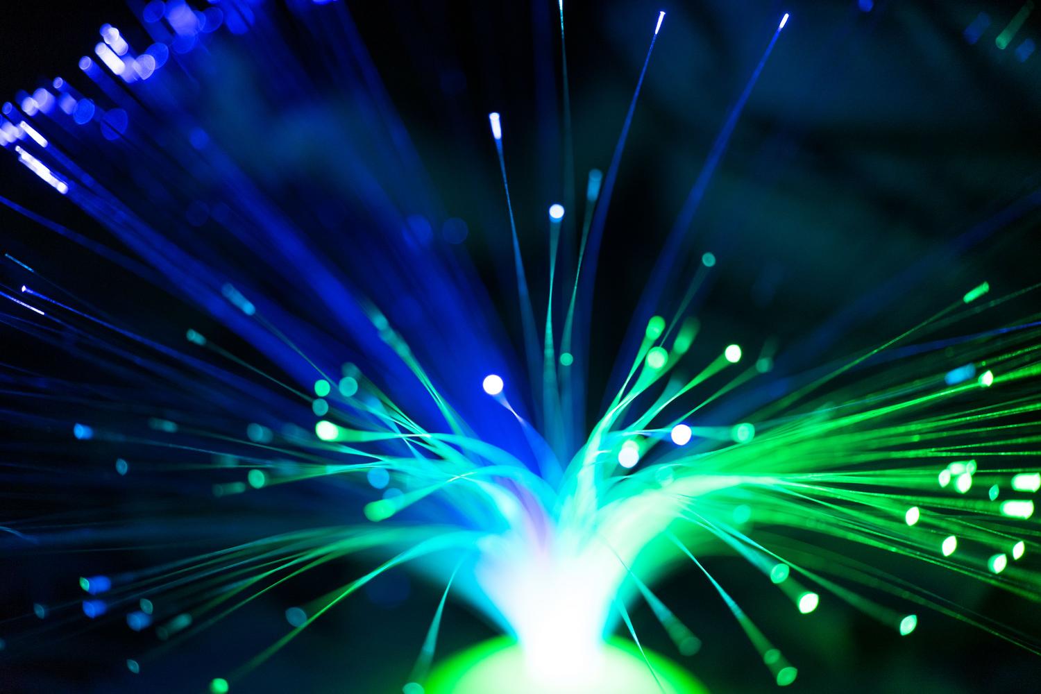Cables de fibra óptica iluminados, simbolizando la conexión de alta velocidad necesaria para el streaming de televisión.