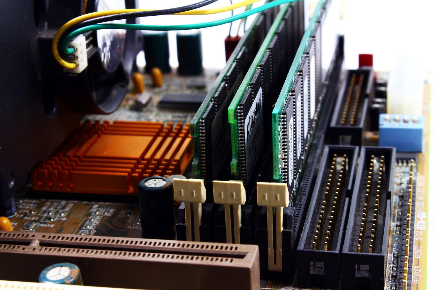 Vista detallada de una placa base de ordenador con módulos de RAM instalados, ilustrando los recursos del sistema.
