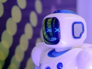 Robot humanoide blanco con ojos LED azules sobre fondo futurista, representando un asistente de IA.