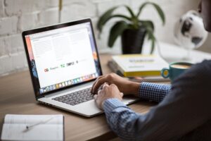 Bărbat care lucrează la un laptop într-un birou modern, reprezentând crearea de conținut și gestionarea blogurilor.
