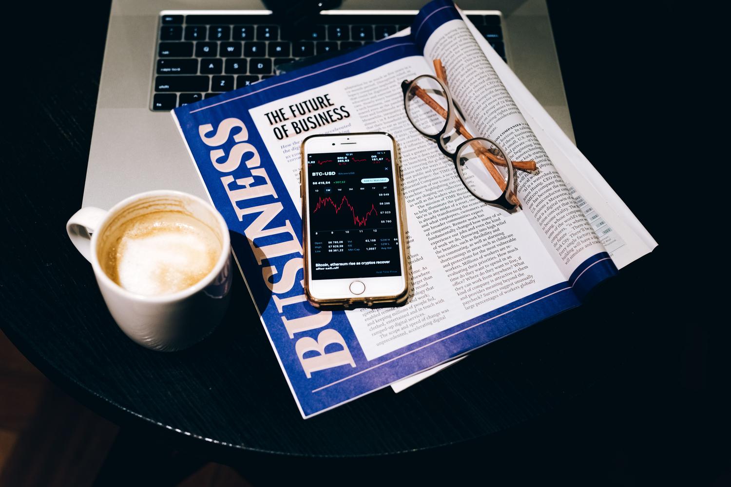 Espacio de trabajo ejecutivo con revista de negocios y tecnología, representando los servicios premium y profesionales.