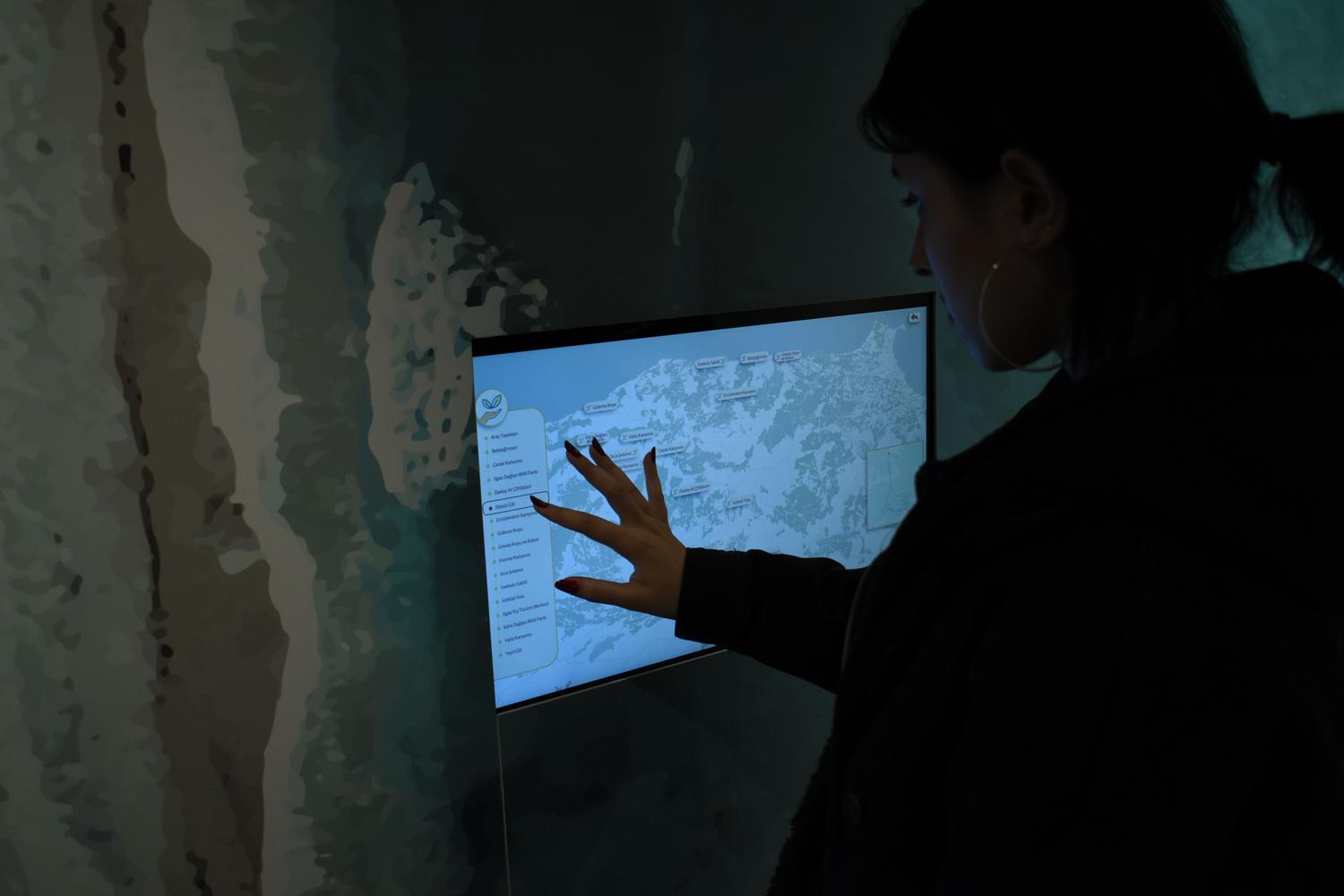 Silueta de una persona interactuando con un mapa digital en una pantalla táctil, sugiriendo el uso de herramientas técnicas como VPN o spoofing.