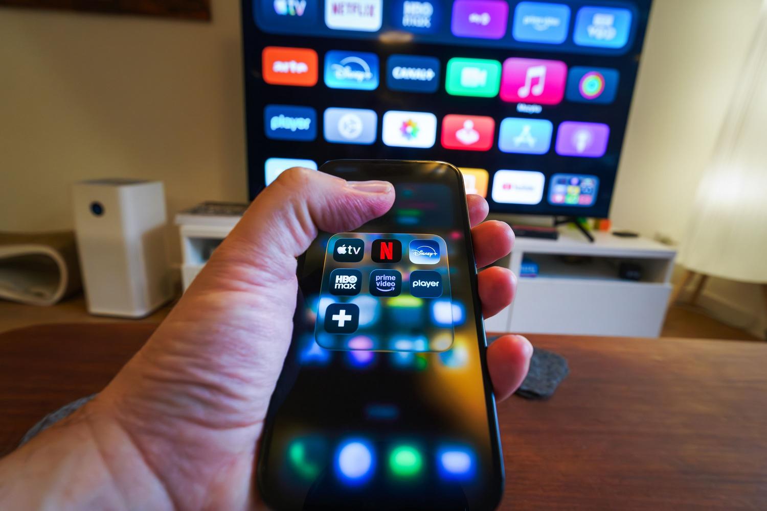 Persona interactuando con aplicaciones de streaming en una televisión, ilustrando el ecosistema de Android TV y la experiencia de usuario.
