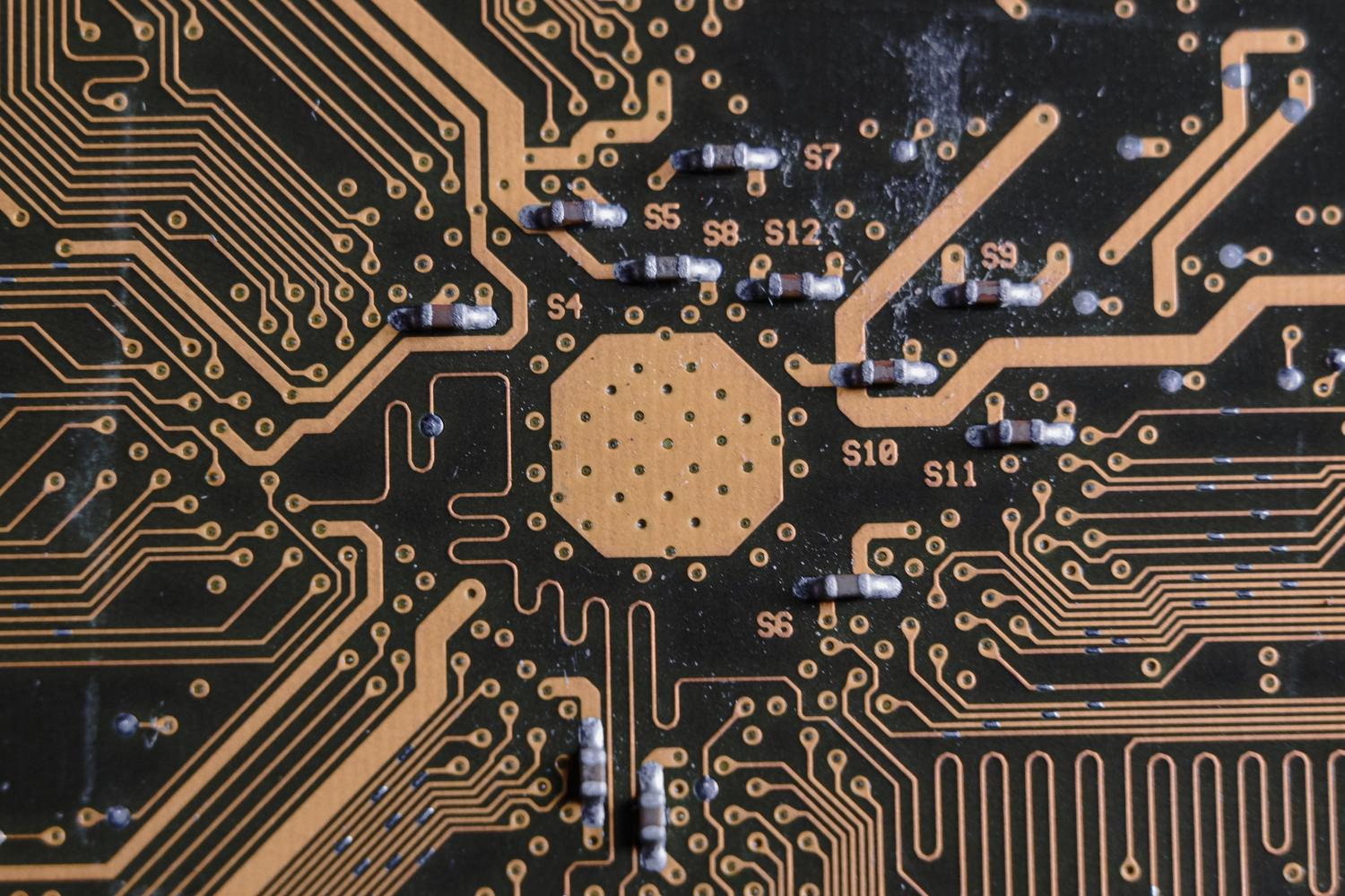Detalle macro de componentes electrónicos y pistas de una placa de circuito, ideal para ilustrar las especificaciones de hardware y conectividad.
