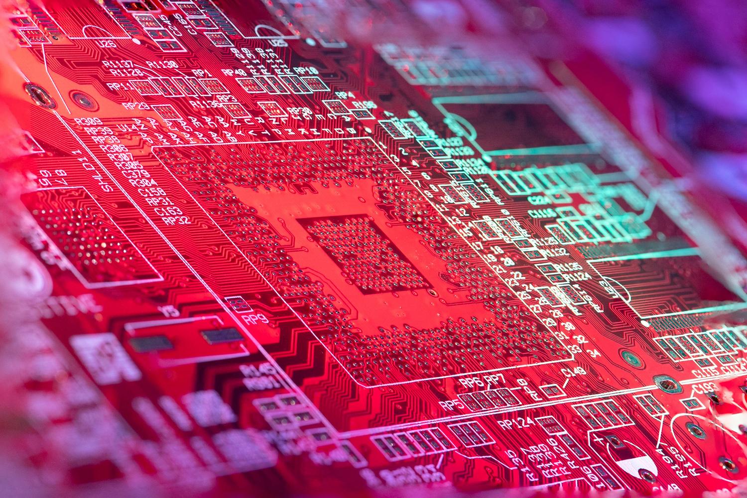 Circuito electrónico iluminado con luces rojas, representando las capacidades de Inteligencia Artificial y procesamiento avanzado del SoC.
