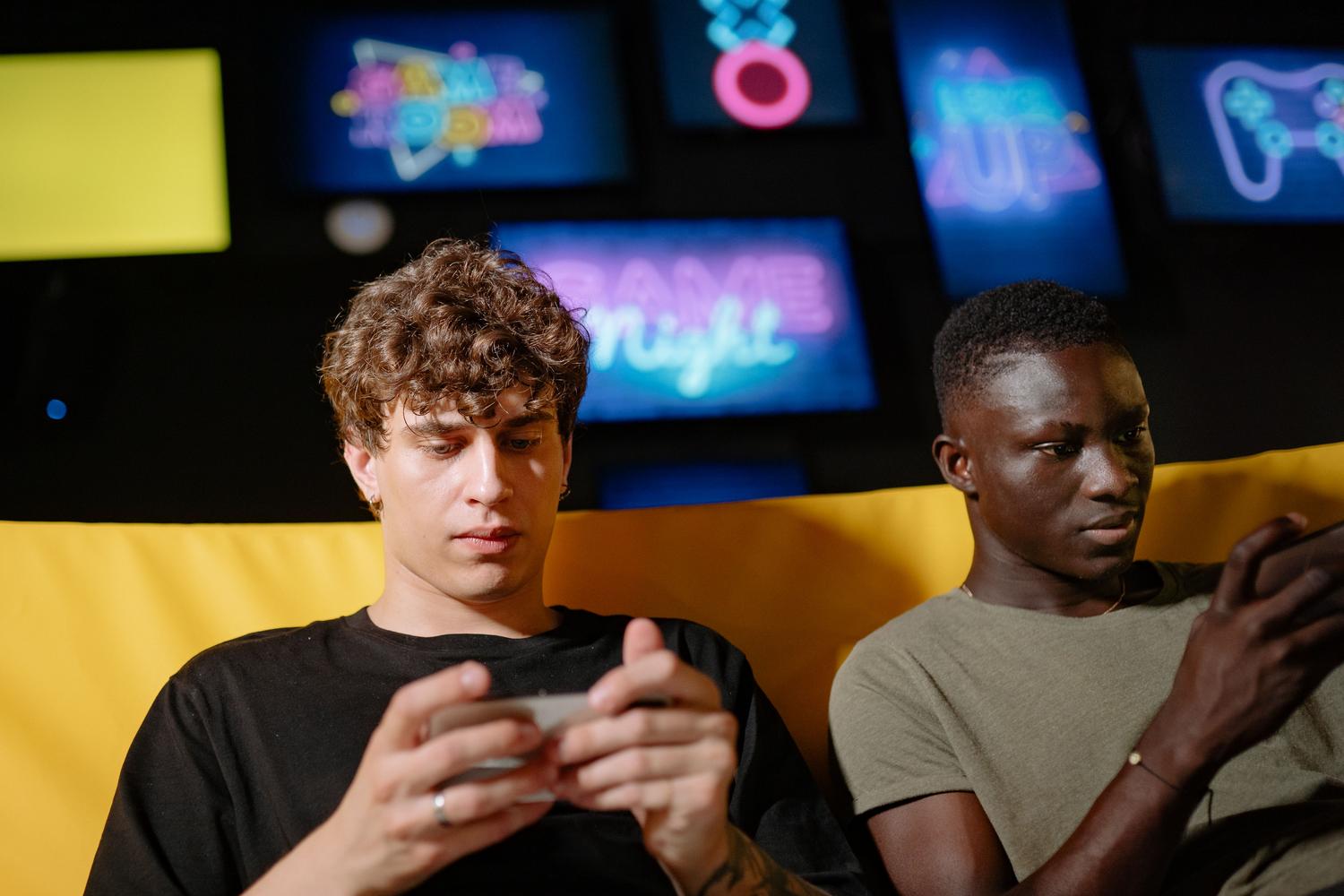 Dos personas utilizando smartphones para jugar, ejemplificando el uso diario y la fluidez en dispositivos de gama media-baja.