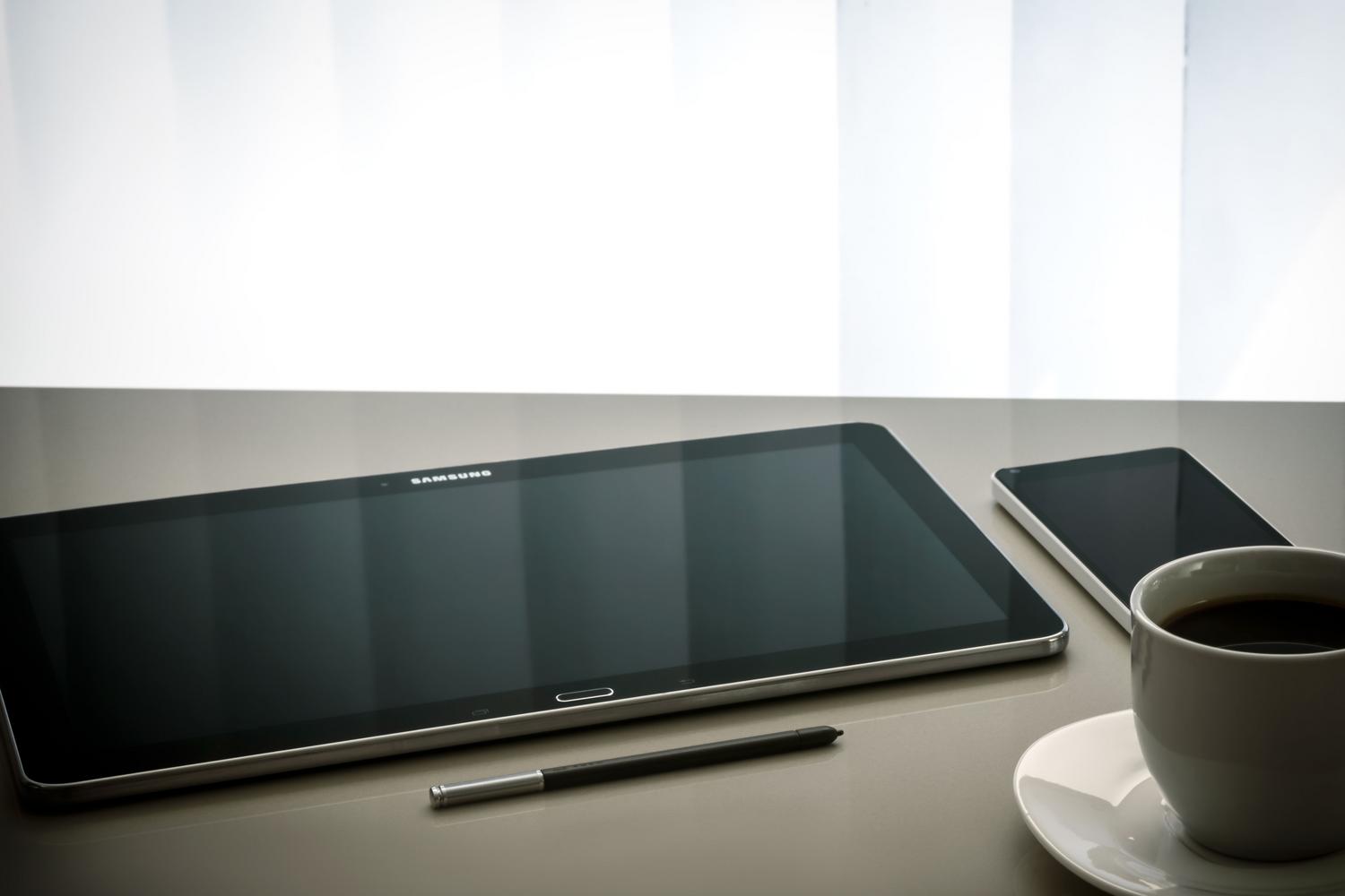 Configuración de escritorio minimalista con una tablet y smartphone, simbolizando el ecosistema de dispositivos de gama media económica.