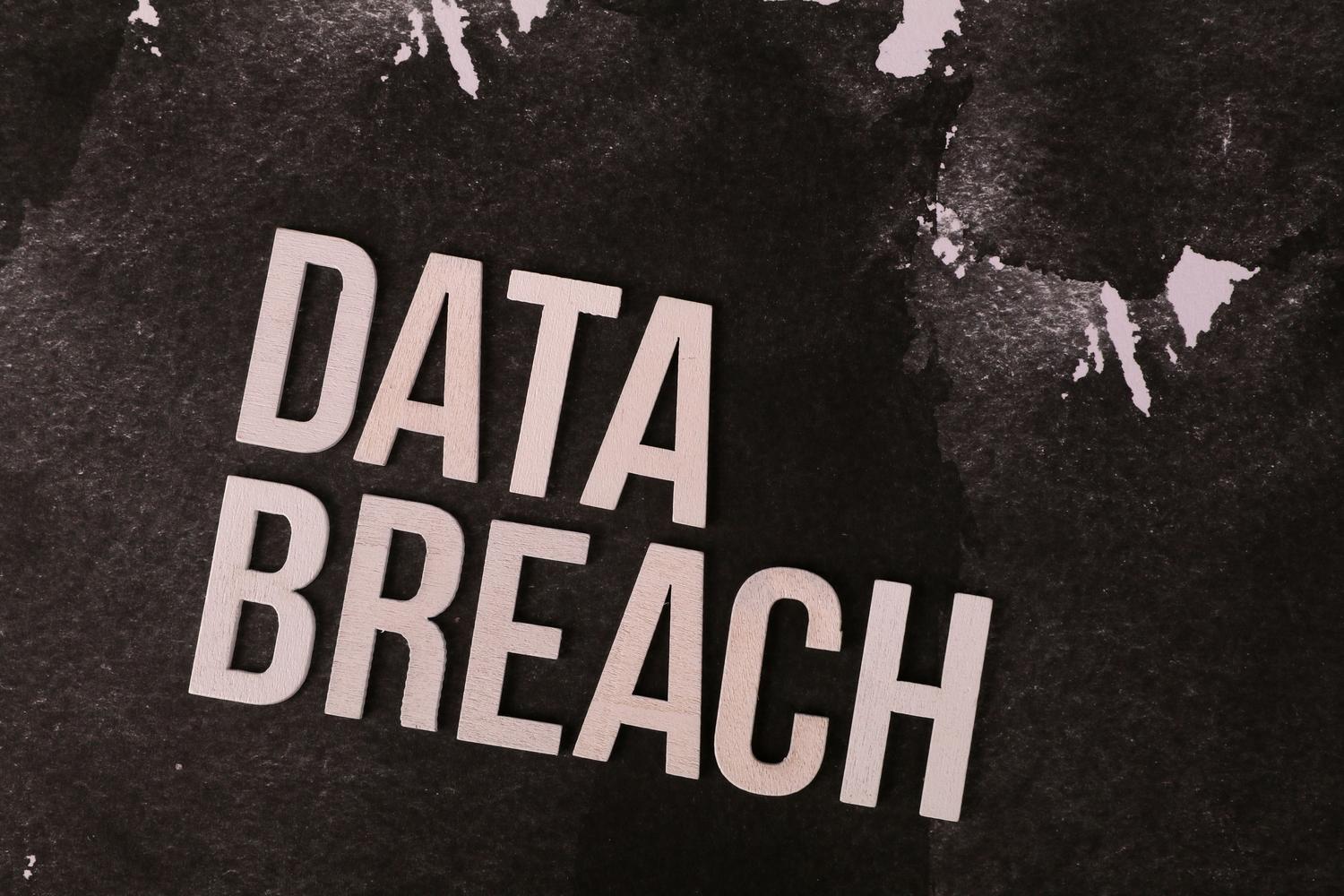Letras de madera formando la frase 'Data Breach' sobre un fondo oscuro, simbolizando los riesgos de privacidad de las VPN gratuitas.
