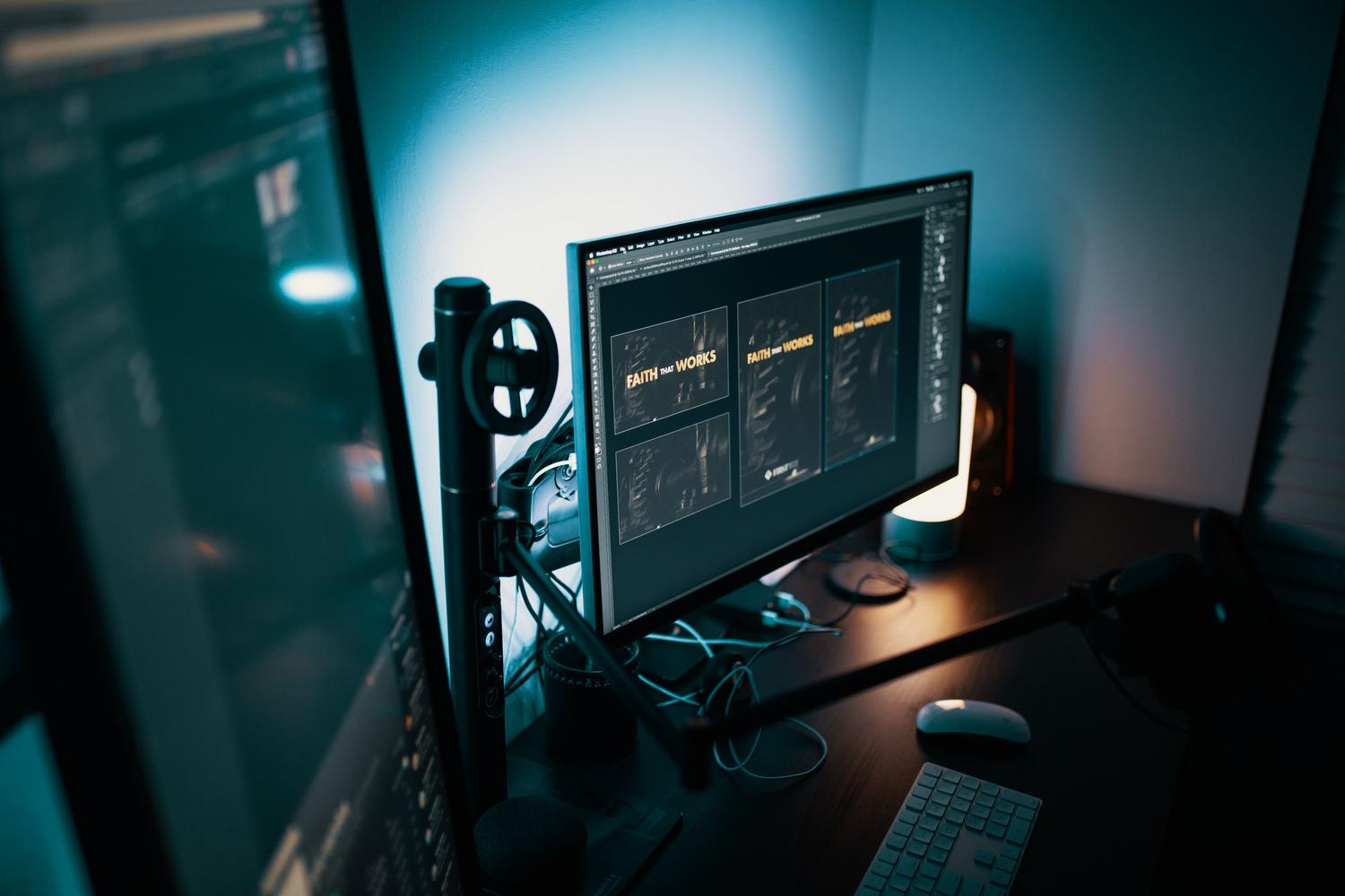 Espacio de trabajo moderno con monitores duales en una habitación con luz tenue, ideal para ilustrar la importancia del control del brillo para evitar la fatiga ocular.
