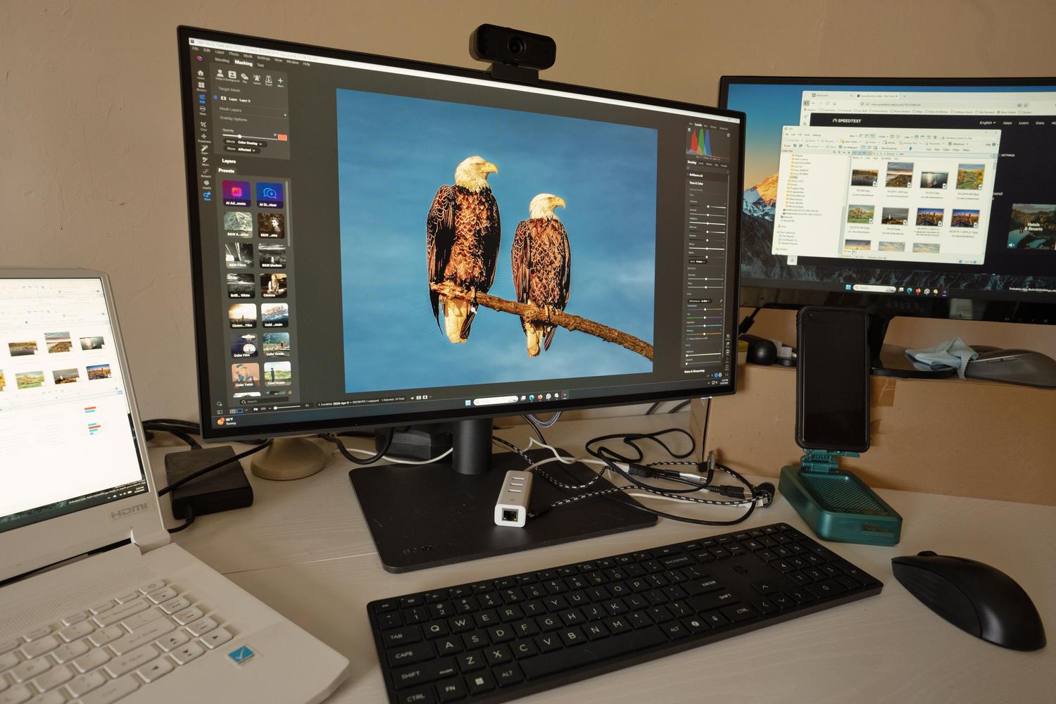 Estación de trabajo profesional con múltiples monitores mostrando software de edición de fotos, perfecta para ilustrar la calibración de color y ajustes de GPU.