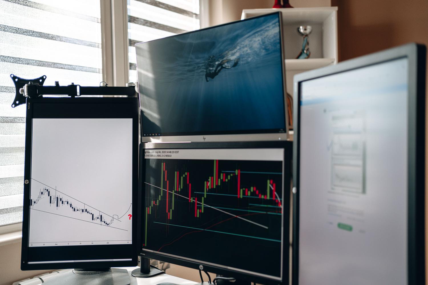 Configuración de oficina en casa con múltiples pantallas mostrando análisis de datos, útil para ejemplificar la gestión de brillo en montajes multimonitor.