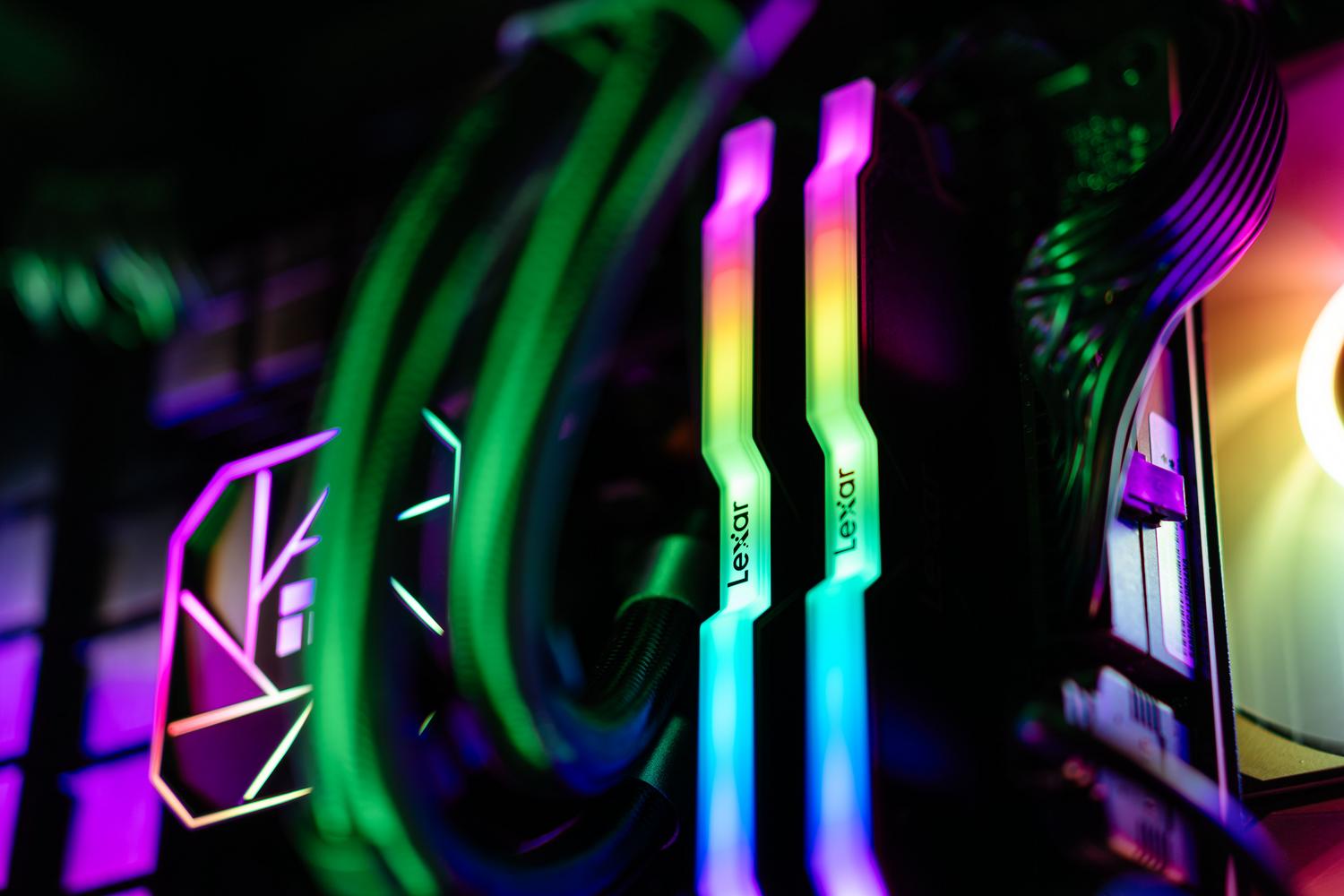 Primer plano de memorias RAM y sistema de refrigeración con iluminación RGB colorida.
