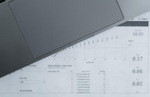 Primer plano de un documento de análisis de datos financieros con un portátil, representando el trabajo con hojas de cálculo en Excel.